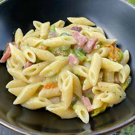 Mezze penne speck, zucchine e fiori di zucca